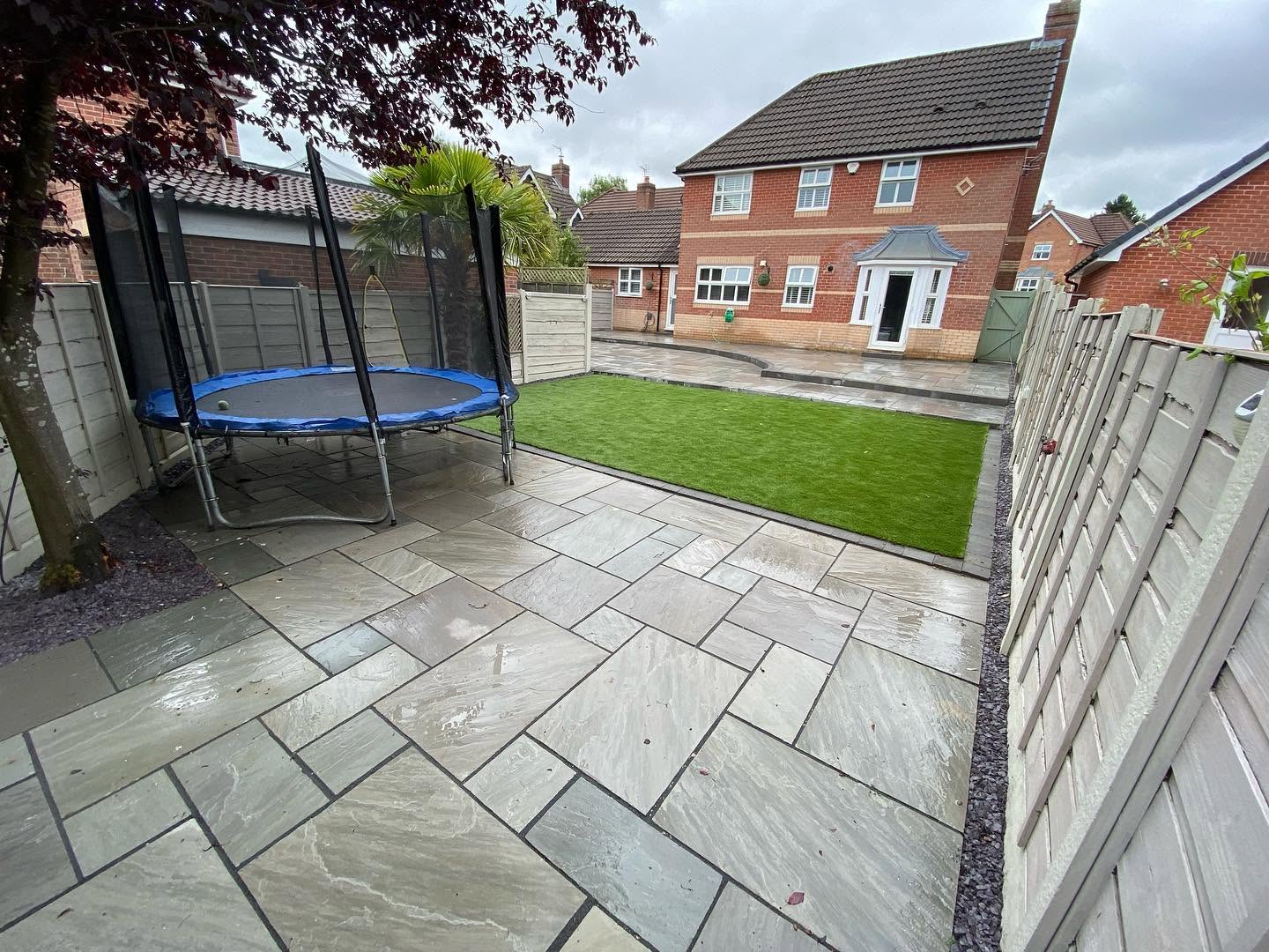 A completed garden transformation — sandstone patio, lawn and family space