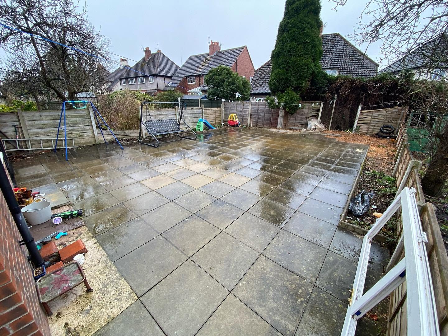 Tired old slab patio before work, looking towards the back of the garden